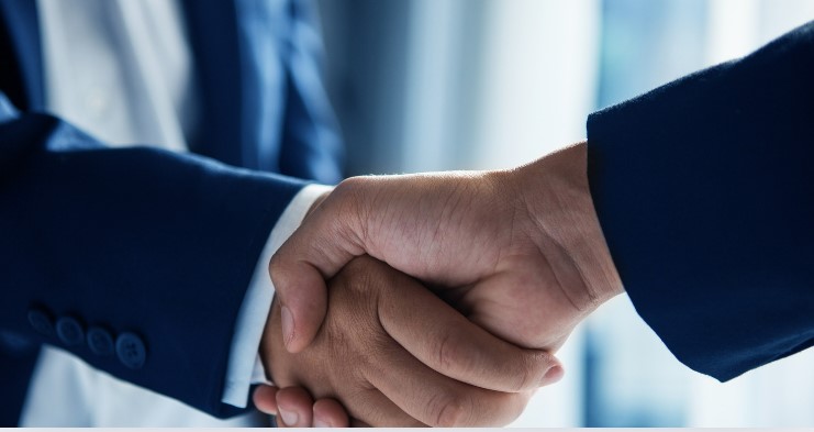 Two people shaking hands to secure a Lower Interest Rate on their Business Debt.